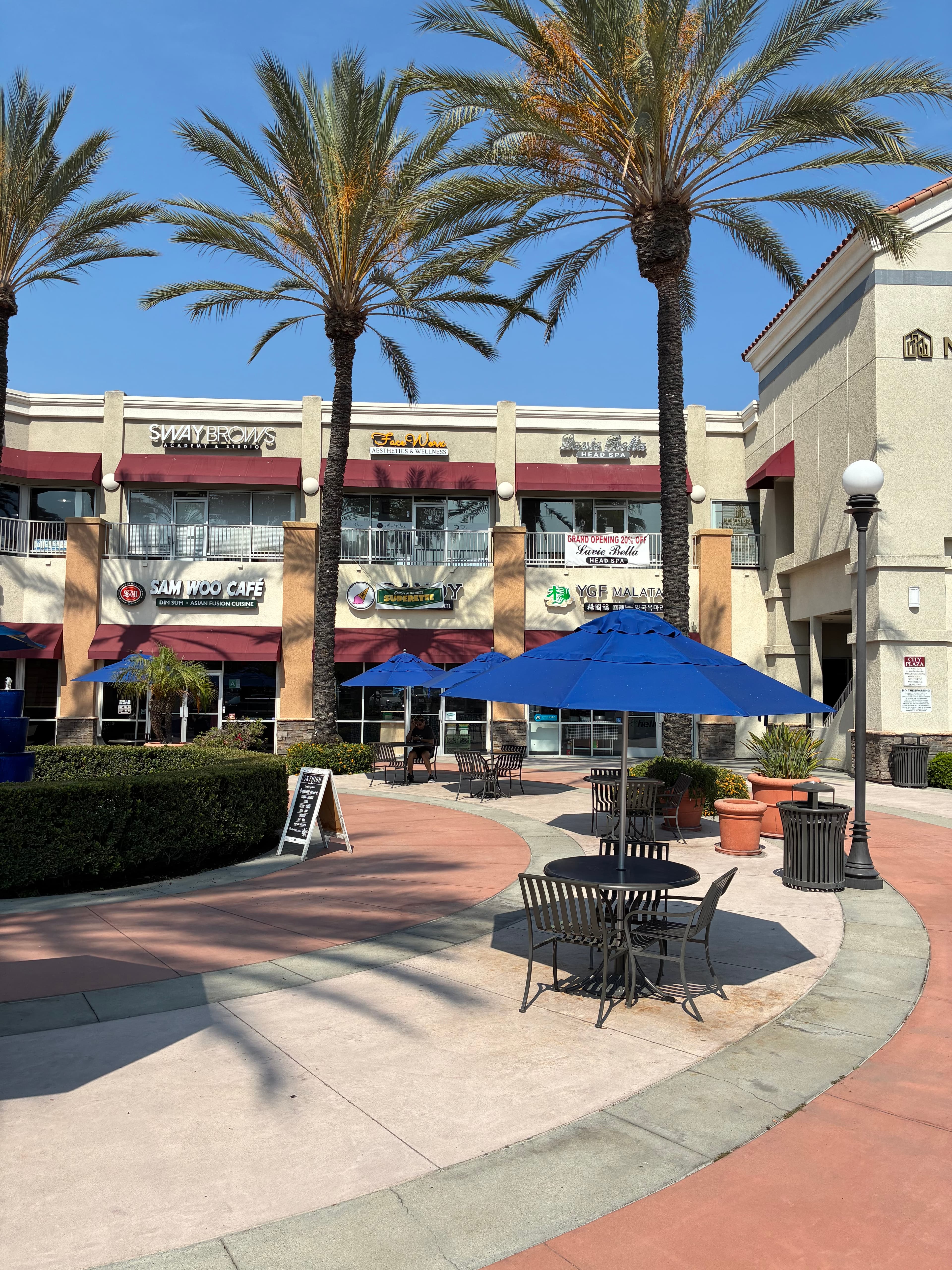 Artesia City Plaza exterior with palm trees — home to Lavie Bella Head Spa, La Tavolata, and more