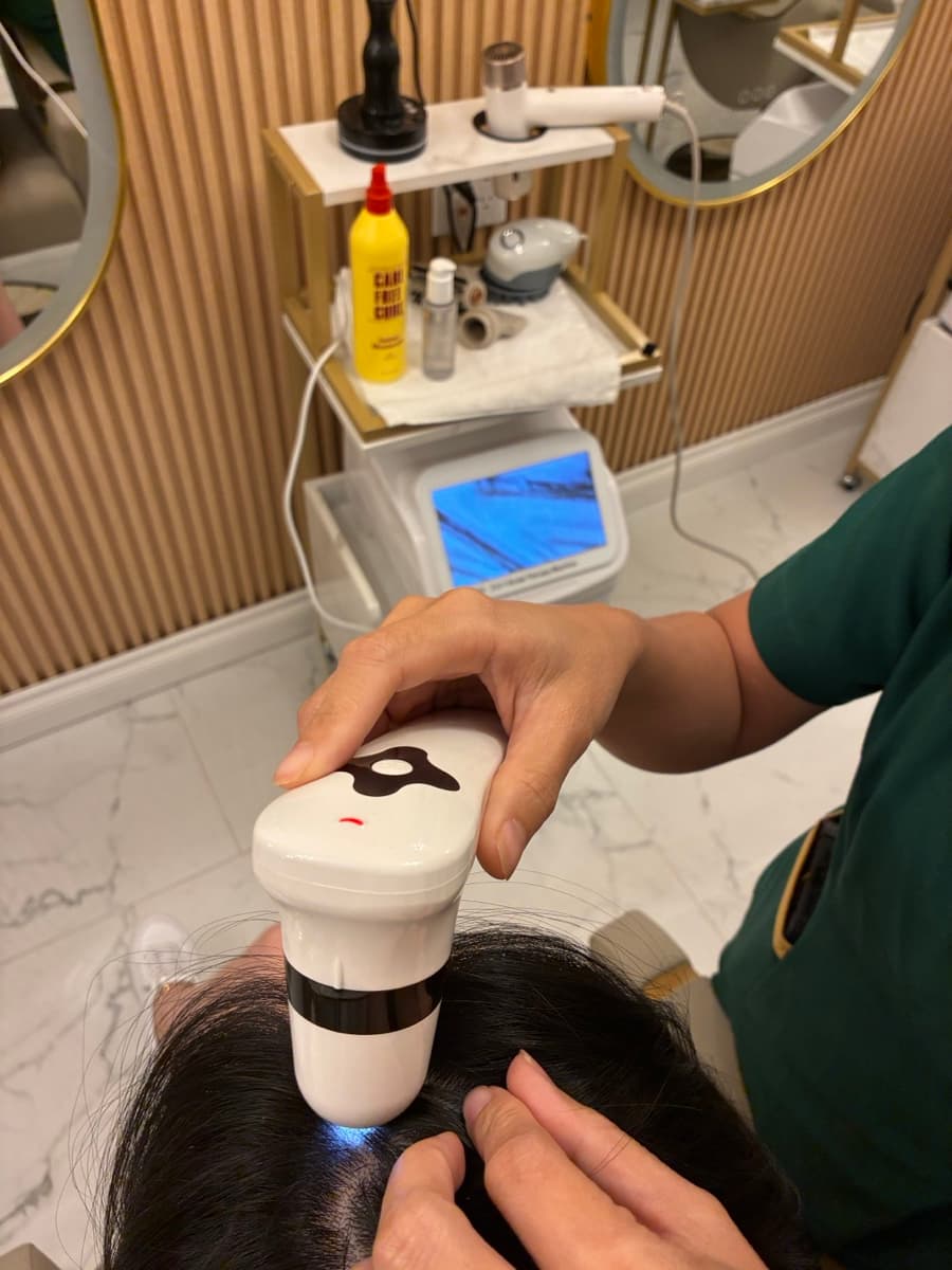 Scalp analysis camera examining client scalp