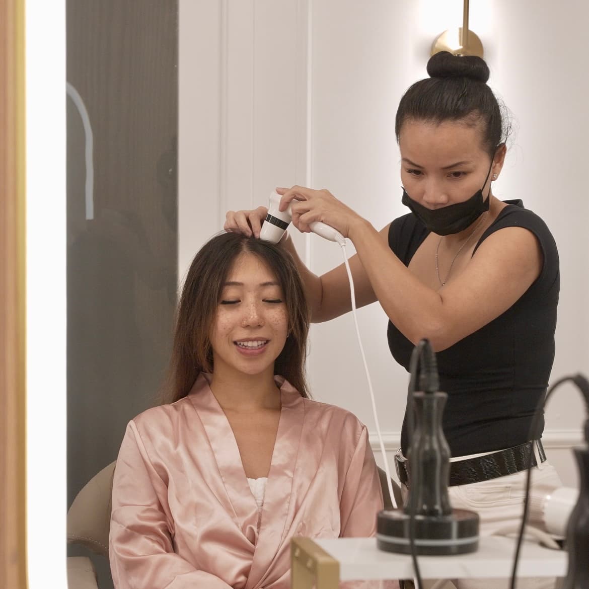 Therapist using scalp analysis device on client